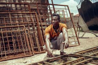 Akwasi sits next to his gates