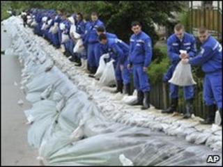 Police academy students load sandbags onto a broken dam to protect homes from flooding in north-eastern Hungary, 18 May 2010