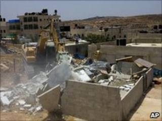 A bulldozer demolishes a house in the east Jerusalem neighbourhood of Beit Hanina, Tuesday 13 July