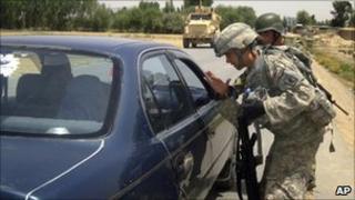 A US soldier talks to a driver during a search for the two missing US Navy personnel in Logar province on 25 July 2010
