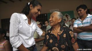 Jessica Anne Jordan Burton shakes the hand of an old lady while campaigning in Bolivia