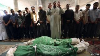 Palestinians pray near the bodies of Ibrahim and Husam Abu Saeed in Jabalya, northern Gaza Strip, 13 September