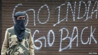 An Indian policeman stands guard near a closed shop during a curfew in Srinagar on Tuesday 14 September 2010