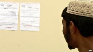 An Afghan man in Kandahar reads a letter posted on the wall by the Taliban, which warns people not to vote in the elections