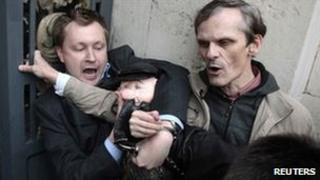 Gay rights campaigner Nikolai Alexeyev (left), clutching a puppet of Yuri Luzhkov, and a second protester resist arrest outside the Moscow mayor's office, 21 September