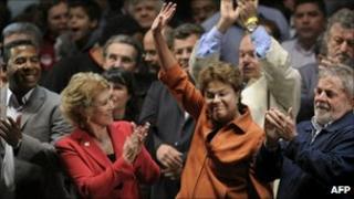 Dilma Rousseff, arms raised, flanked by President Lula (right) and PT congressional candidates Marta Suplicy and Netinho de Paula