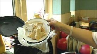 Woman putting scraps of bread into one of the recycling bins