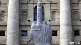 L.O.V.E. - a statue by controversial Italian artist Maurizio Cattelan - in front of the stock exchange in Milan