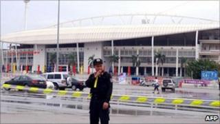 A military policeman stands outside the My Dinh stadium after the explosion (6 October 2010)