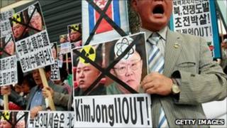 South Korean protesters hold portraits of North Korean leader Kim Jong-il and his son