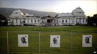 Photos of Lesley Voltaire, left, Charles Henry Baker, centre, and Jean Hector Anacasis, all running for the presidency, are stuck on a fence surrounding the earthquake-damaged National Palace in Port-au-Prince, Haiti
