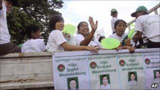 Members of the Union Solidarity and Development Party (USDP) wave from a campaign vehicle on 13 October 2010
