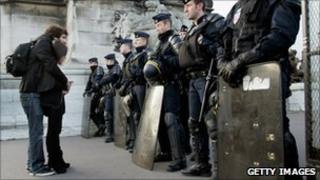 People stand in front of police during a protest in Paris, 19 October 2010