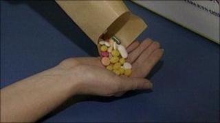 Person pouring pills from envelope