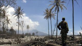 A soldier looks at Mount Merapi from an ash-covered field on 15 November 2010