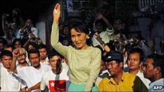 Aung San Suu Kyi waves to supporters as she arrives at NLD headquarters in Rangoon