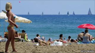Sunbathers on the beach in Barcelona (with a yacht race going on in background), July 2010
