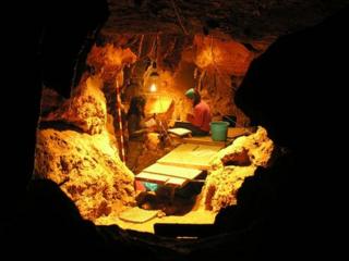 Archaeologists excavate the cave in El Sidron in Asturias, northern Spain