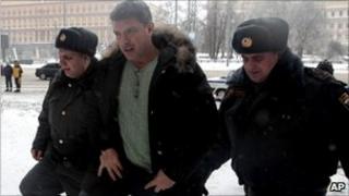 Russian opposition leader Boris Nemtsov is escorted to court in Moscow, Russia, Sunday, Jan. 2, 2011