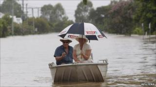 A couple make their way through Depot Hill, Rockhampton, as rain falls on 6 Jan 2010
