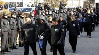 South Korean policemen lead Somali suspected pirates to the headquarters of the Namhae Maritime Police Agency in Busan, South Korea, 30 January 2011
