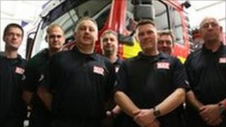 Some of the firefighters standing in front of a fire engine