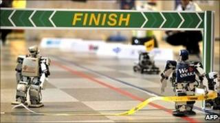 Robovie-PC (right) crosses the finish line in the world's first full-length marathon for two-legged robots in Osaka, Japan, 26 February 2011
