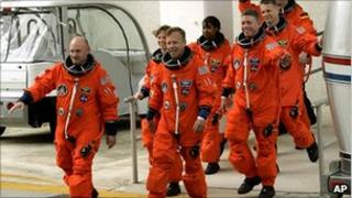 Lisa Nowak, second from left, and other astronauts in flight gear on a tarmac