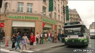 Parisians pass by an M&S store in Paris on opening day 1994