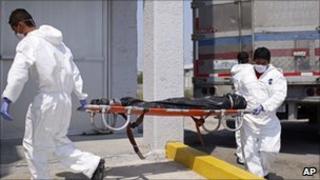 Morgue employees take a body to the local morgue in Matamoros