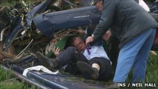 Nigel Farage being helped from the wreckage of the plane by a passer-by
