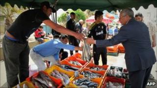 Libyans buy fish at a market in Tripoli on 19 April as Nato air strikes hit the Libyan capital