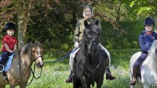 Queen riding in Windsor Great Park with her two youngest grandchildren