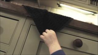 Still from film showing boy pulling tea towel from work surface