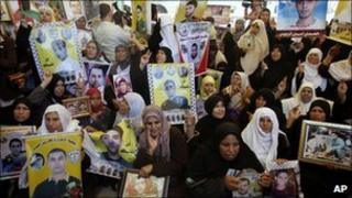Palestinian women hold pictures of relatives held in Israeli jails during a weekly protest calling for the release of Palestinian prisoners, in Gaza City, 9 May 2011