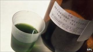 Bottle containing methadone and a measure of the drug