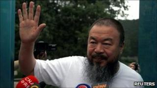 Dissident Chinese artist Ai Weiwei waves from the doorway of his studio after he was released on bail in Beijing (23 June)