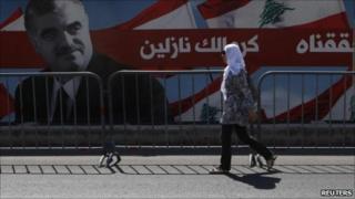 Beirut - Woman walks in front of Hariri poster. 30 June 2011