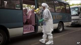 A Japanese evacuee, wearing a suit to protect him against radiation, boards a bus Minamisoma to take him to his home village of Namie inside the nuclear exclusion zone - 27 May 2011