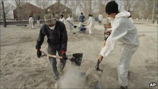 Volunteers remove volcanic ash, brought by Chile's Puyehue-Cordon Caulle volcano, from the ground in Ingeniero Jacobacci in southern Argentina, on 20 June, 2011