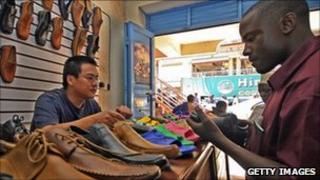 A Ugandan browses at shoes in a Chinese-owned shop in Kampala (archive shot)
