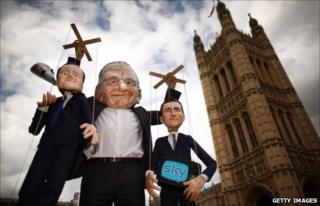 Puppets representing UK Prime Minister David Cameron (L) and Culture Secretary Jeremy Hunt (R) are held aloft by Rupert Murdoch in London (7 July 2011)