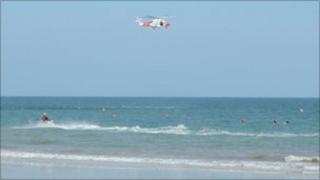 The Portland Coastguard helicopter assisting the RNLI at Boscombe beach, Bournemouth