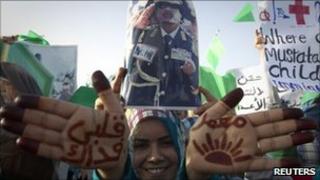 A pro-Gaddafi demonstrator shows script on her hands reading "I'll sacrifice my life for Muammar" in Sirte, the hometown of Libyan leader Col Gaddafi, on 21 July.