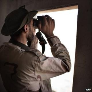 Libyan rebel looks at government forces at the desert outpost of Twama, 30 km south-east of the western stronghold of Zintan (15 July 2011)