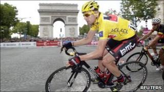 Cadel Evans of Australia, wearing the leader's yellow jersey, takes a curve in front of Paris' Arc de Triomphe during the final stage of the 98th Tour de France cycling race, 24 July 2011