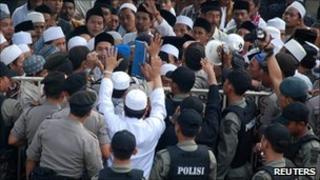Indonesia police block Muslim supporters who are rallying in support of men accused of assault on members of the Ahmadiyah sect