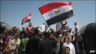 People watching the trial of Hosni Mubarak on an outdoor TV screen in Cairo