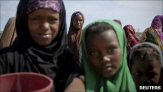 Women and children queue to receive food at a World Food Programme food distribution centre in Mogadishu, Somalia on 4 August 2011
