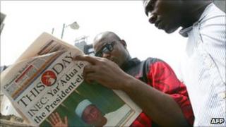 Nigerians reading a newspaper